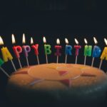 HAPPY BIRTHDAYのキャンドルが灯ったバースデーケーキ