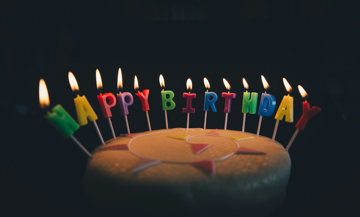 HAPPY BIRTHDAYのキャンドルが灯ったバースデーケーキ